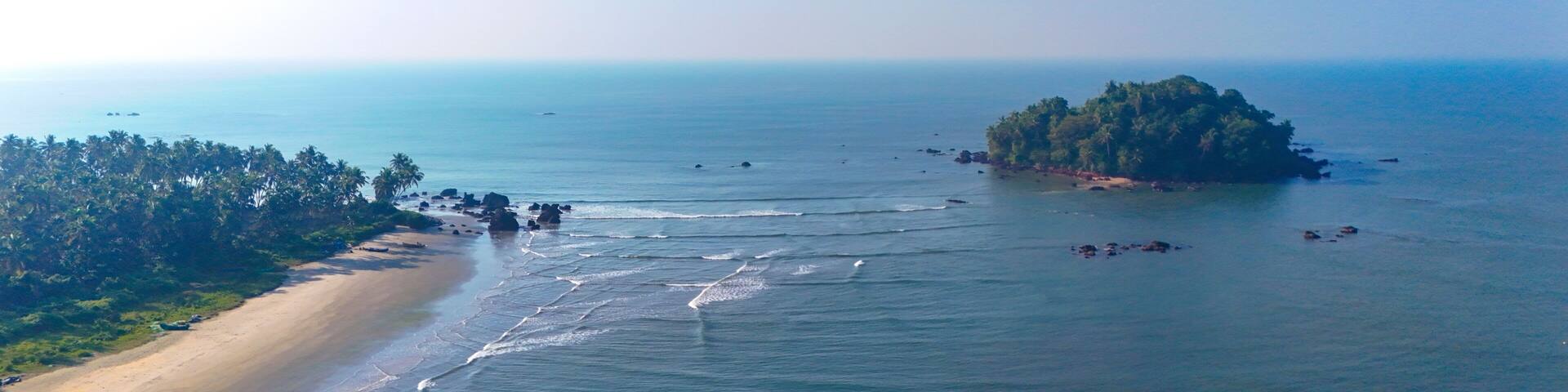 Breathtaking aerial view of Dharmadam Island, a private island covered in coconut trees located off the coast of Thalassery in Kannur, Kerala.
