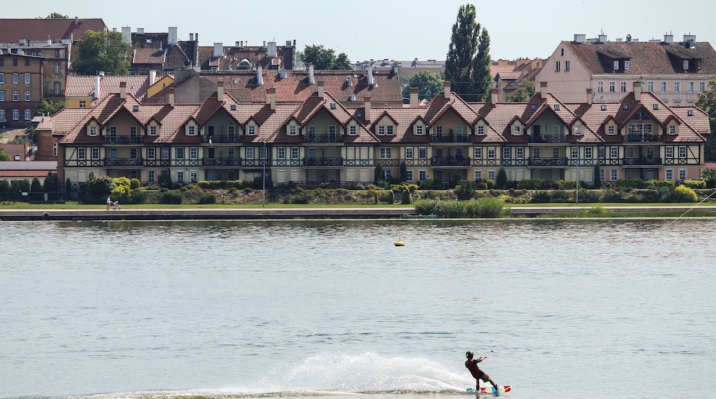 a boy riding a kiteboard against a background of picturesque houses in Ostroda, Poland; Shutterstock ID 518280943
