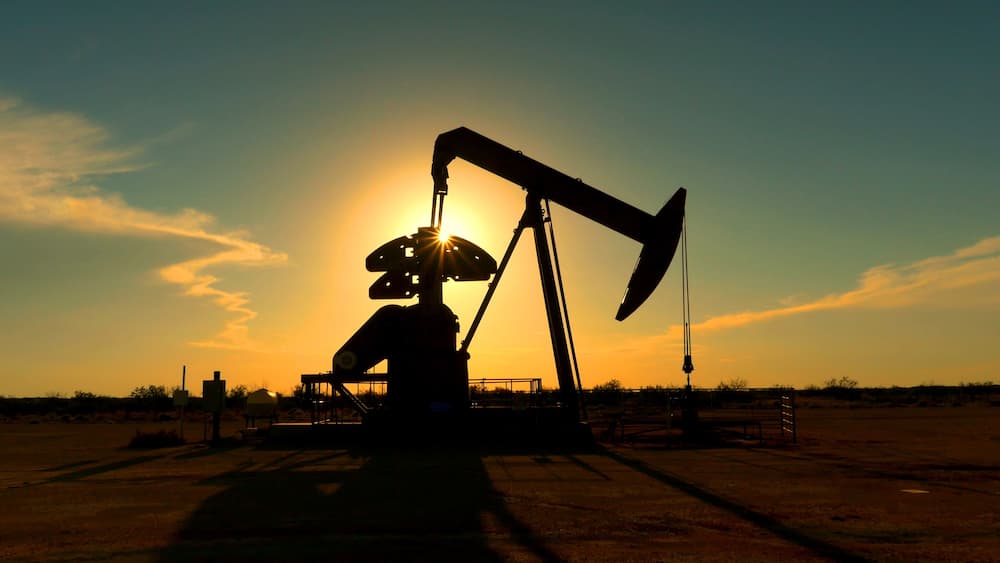 An oil pumpjack silhouetted against a sunset.