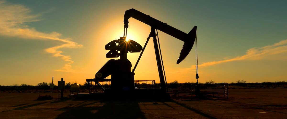 An oil pumpjack silhouetted against a sunset.