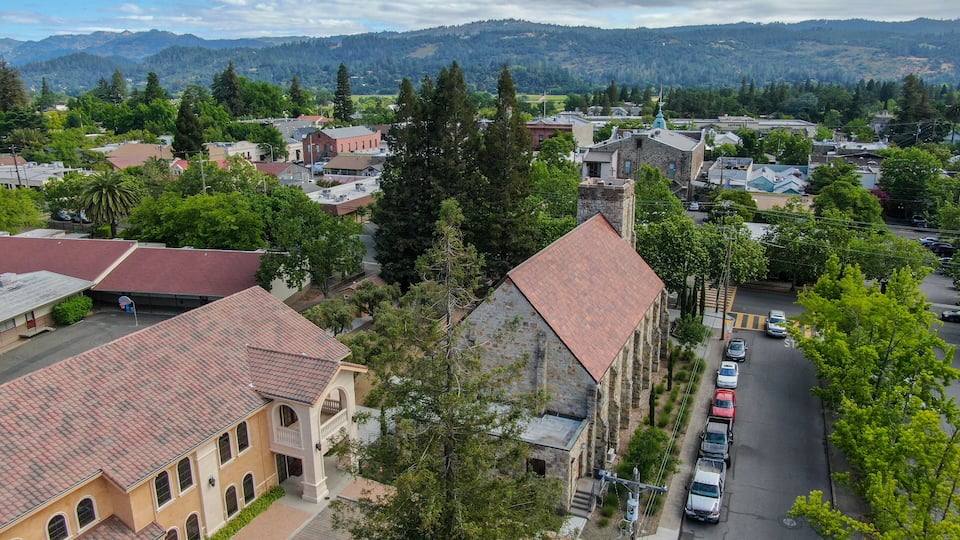 A town with historic buildings, a church, and a mountainous backdrop.