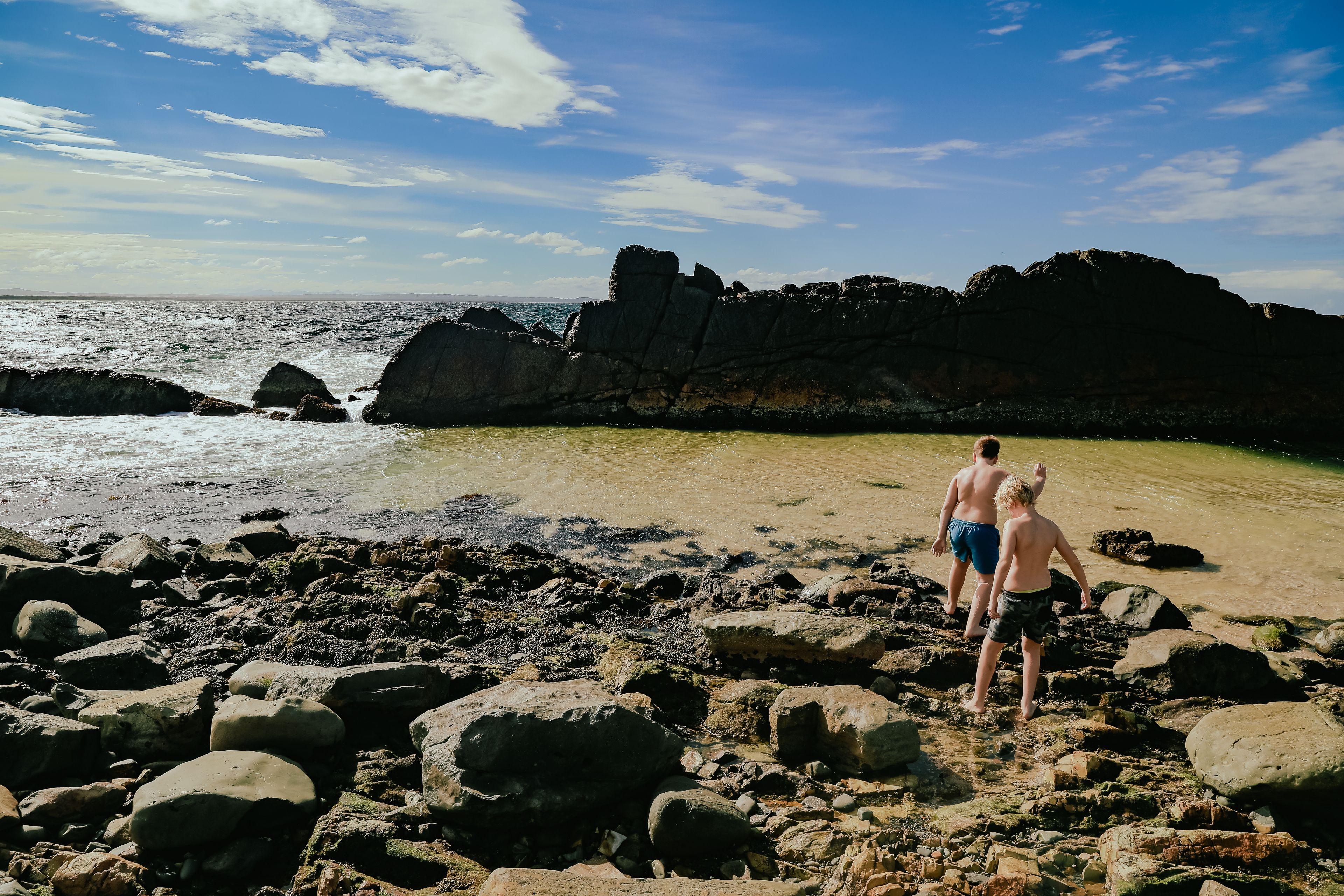 Children swimming at The Tanks tourist attraction natural rock pool at Forster, NSW Australia
