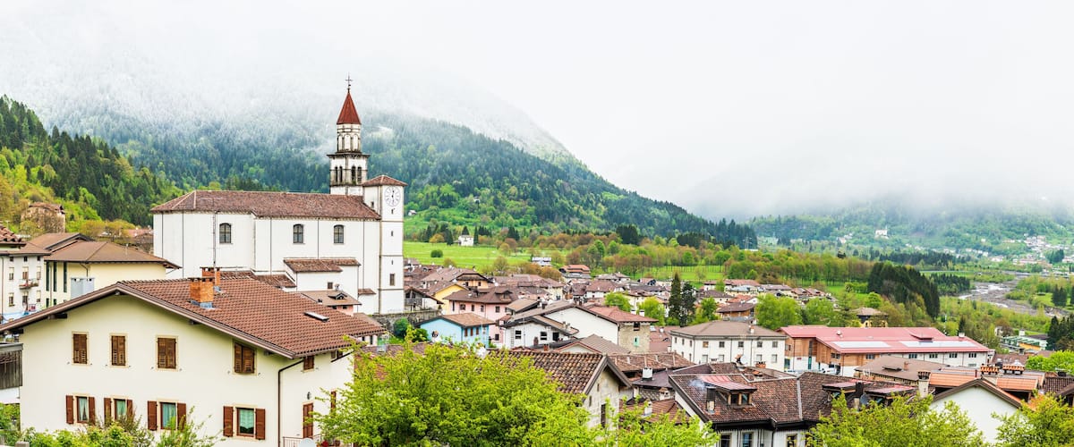 A village with a church, houses, and a mountain in the background.