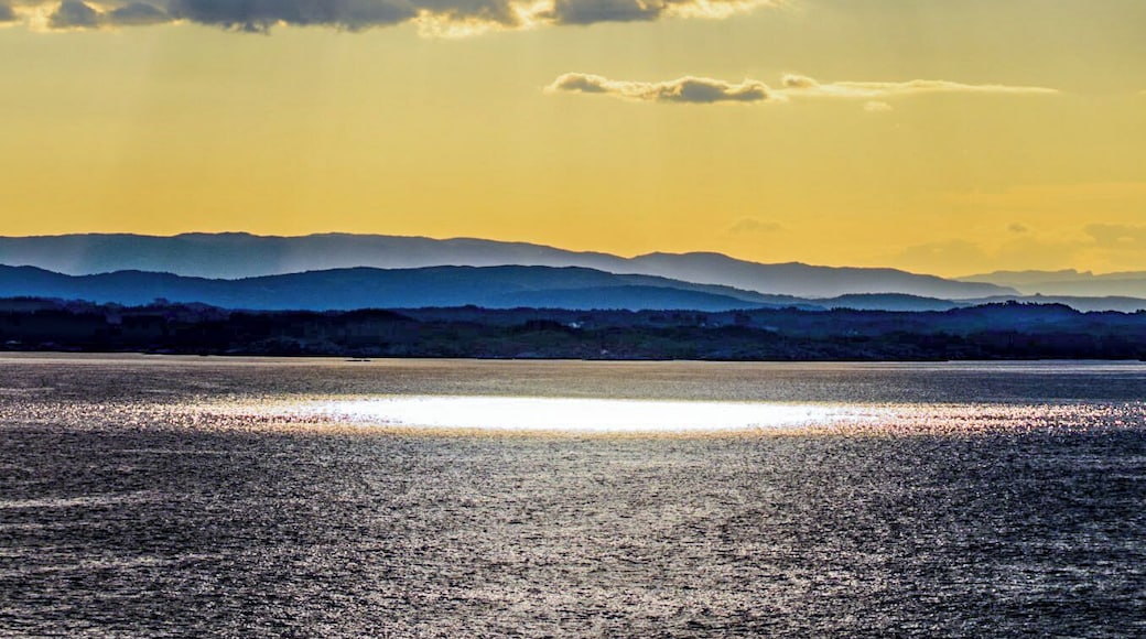 Sun breaks through a crack in the cloud of the Norwegian coastline.