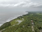 Aerial view of Kihim beach in the coastal area of Alibag, Maharashtra India. The landscape panorama was taken on a cloudy day in August. A Fisherman parked their boat at a jetty.