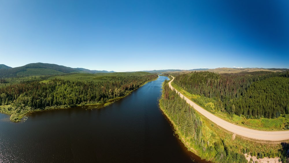 Scenic Panoramic Lake View of Curvy Road in Canadian Nature on a Sunny Summer Day. North of Prince George, John-Hart Highway, British Columbia.