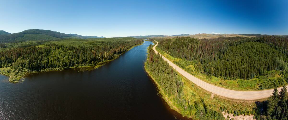 A river winding through a forested valley with a road curving alongside.