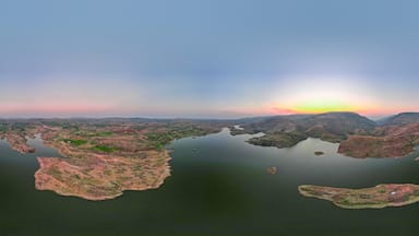 A panoramic view of a lake surrounded by hills and small islands.