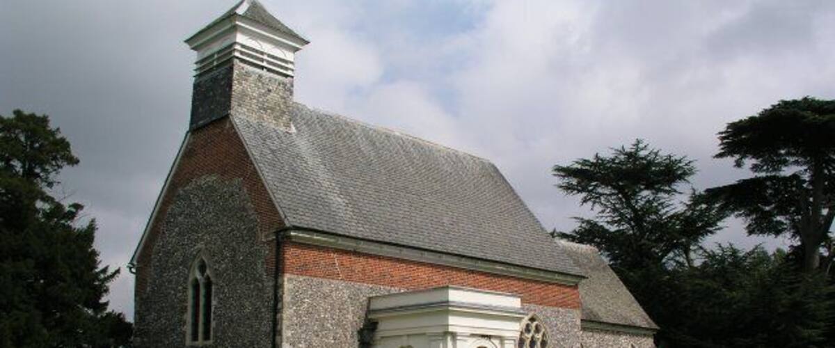 A church with a stone facade, a white door, and a bell tower.