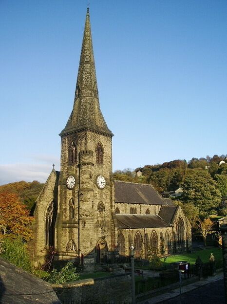 A church with a tall spire and two clocks on the tower.