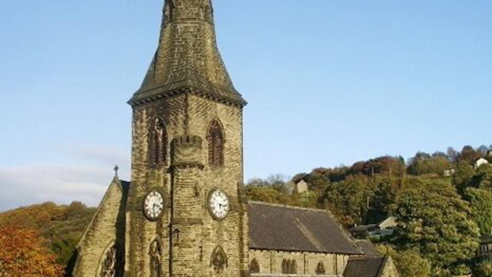 A church with a tall spire and two clocks on the tower.