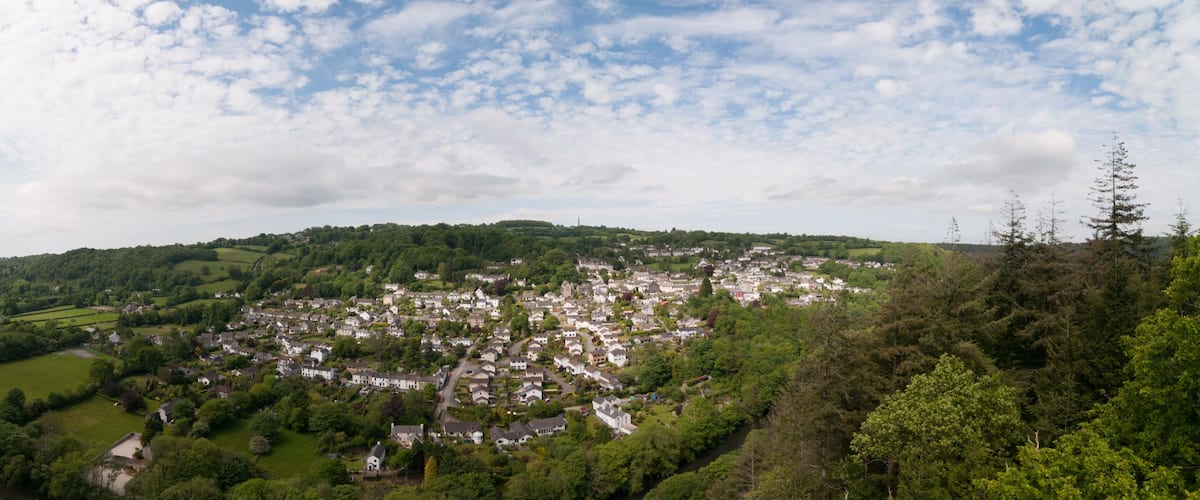 A valley with a river, a town, and surrounding forested hills.