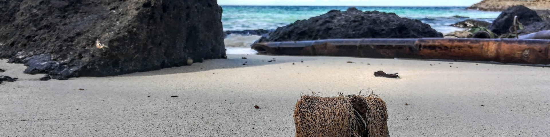 The Southern tip of the Island on the East side doesn't look like anywhere else in the area.  Instead of limestone rocks, there are sharp black basalt boulders around a natural cove of coral sand.  Perfect for a picnic.