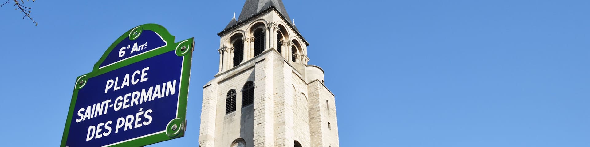 A church with a tall bell tower and a sign indicating 'Place Saint-Germain des Prés'.