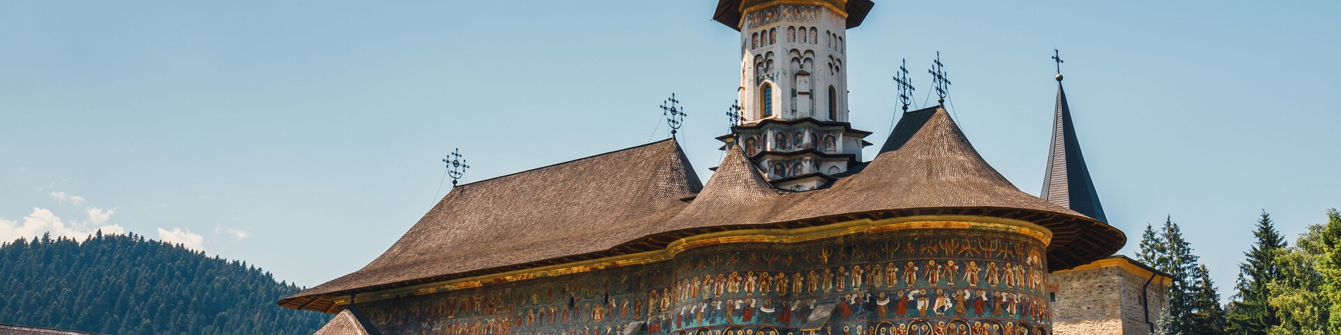Una iglesia histórica con una torre alta y frescos intrincados.