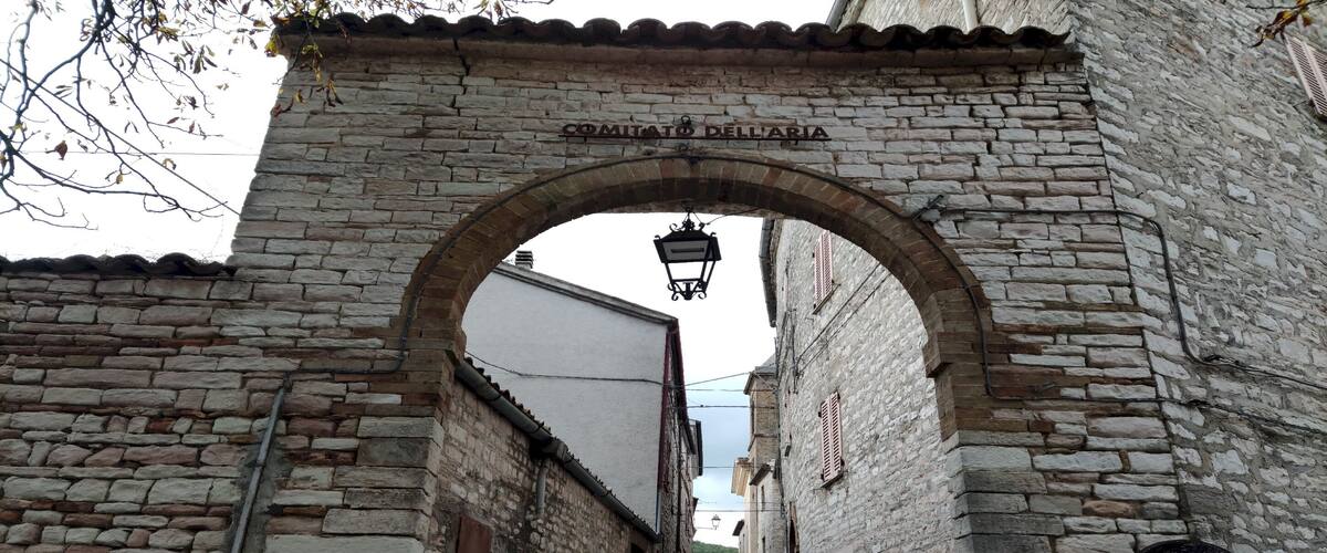 A stone archway with 'COMMITATO DELL'IA' inscribed above.