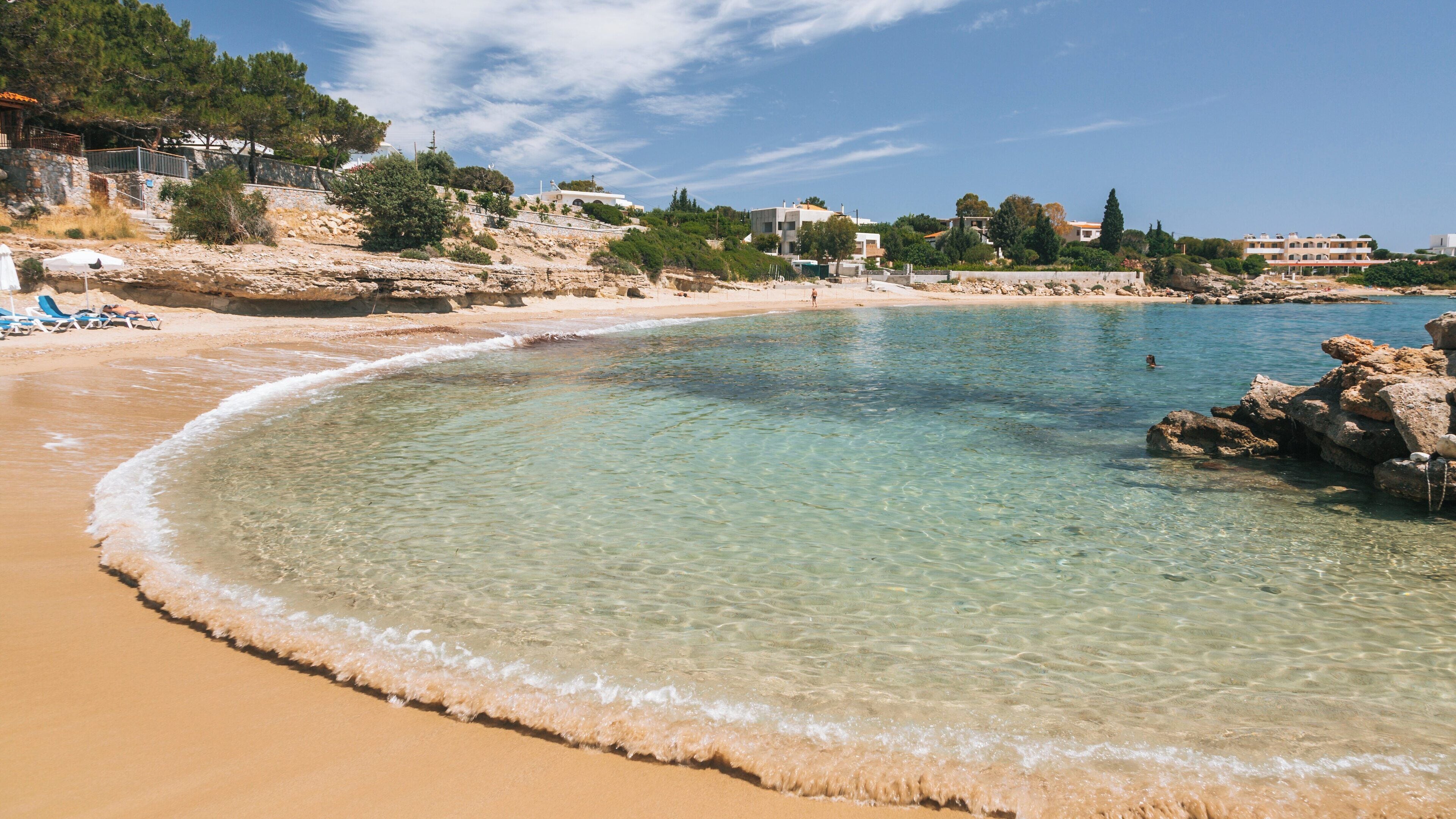 Pefkos Beach showcases clear turquoise waters and golden sands along the coast of Rhodes, inviting relaxation and enjoyment on a sunny day