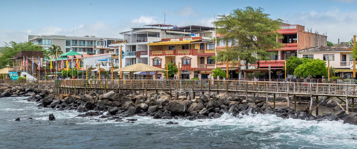 A coastal town with colorful buildings, a rocky shoreline, and waves crashing against the rocks.