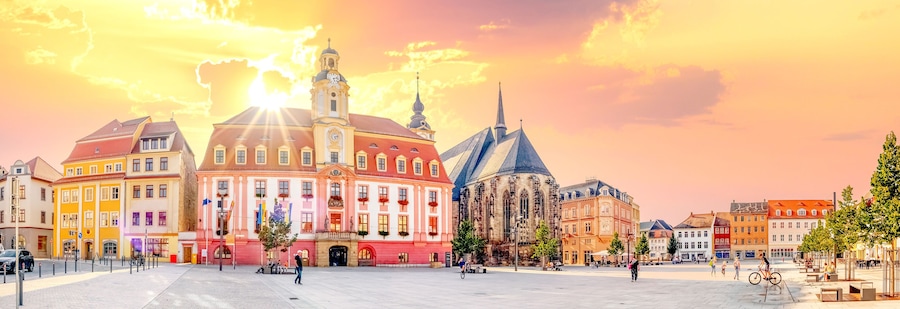 Una plaza histórica con una iglesia destacada, edificios coloridos y un cielo despejado.