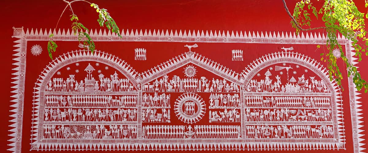 A detailed white painted mural on a red background, depicting various figures and scenes, with some areas of peeling paint.