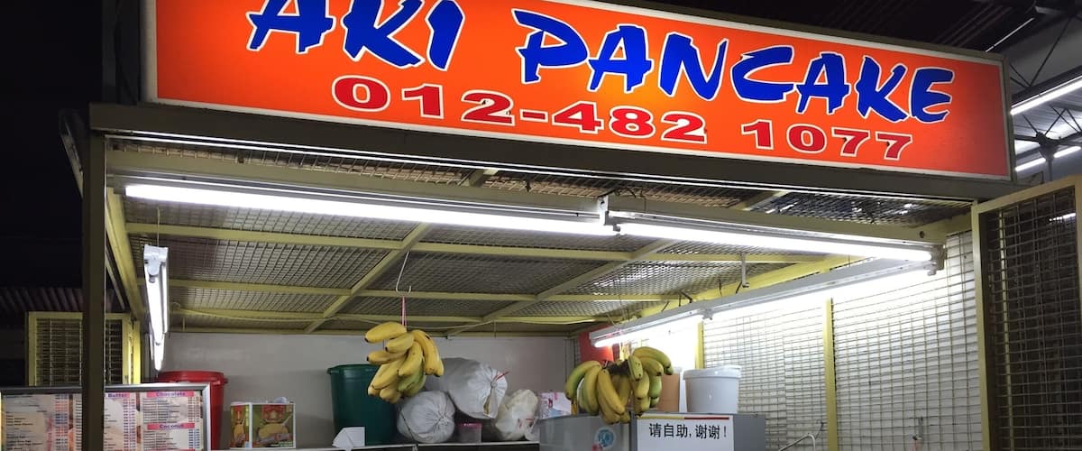 A street food stall named "Aki Pancake" with a phone number 012-482-1077.