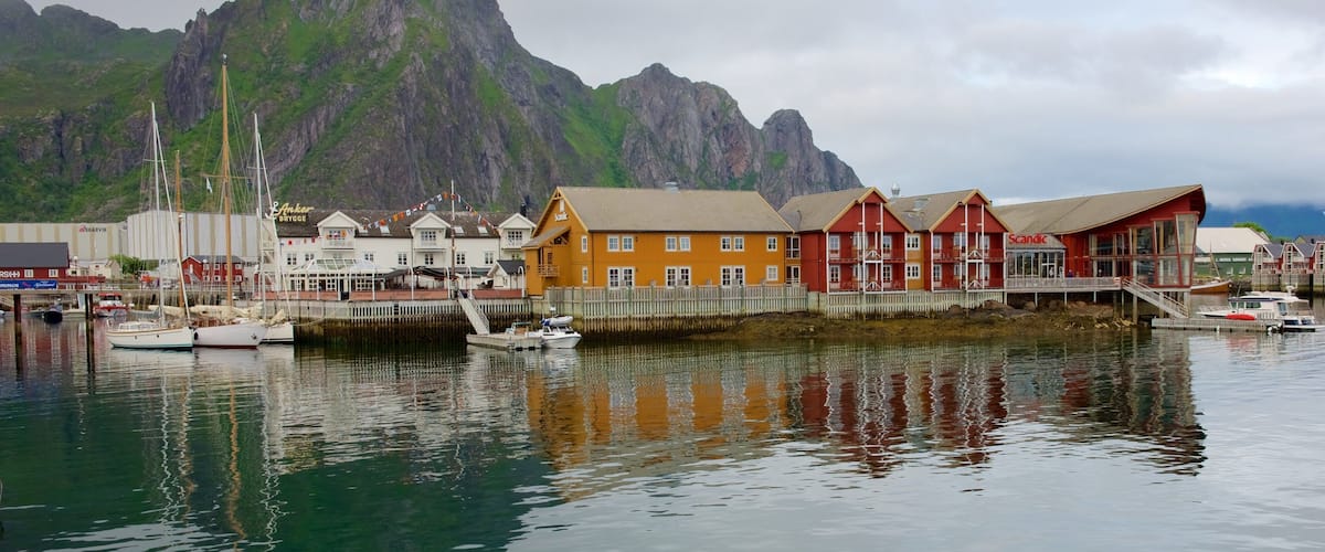 A harbor with boats, a mountain, and colorful buildings.