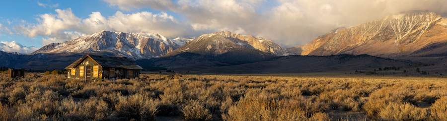 Abandoned old house at sunrise in front of the California Sierra Nevada mountains