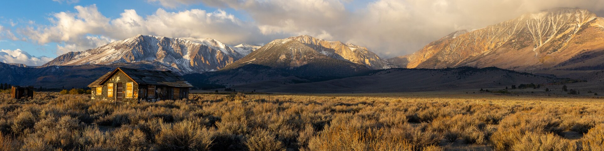 Abandoned old house at sunrise in front of the California Sierra Nevada mountains