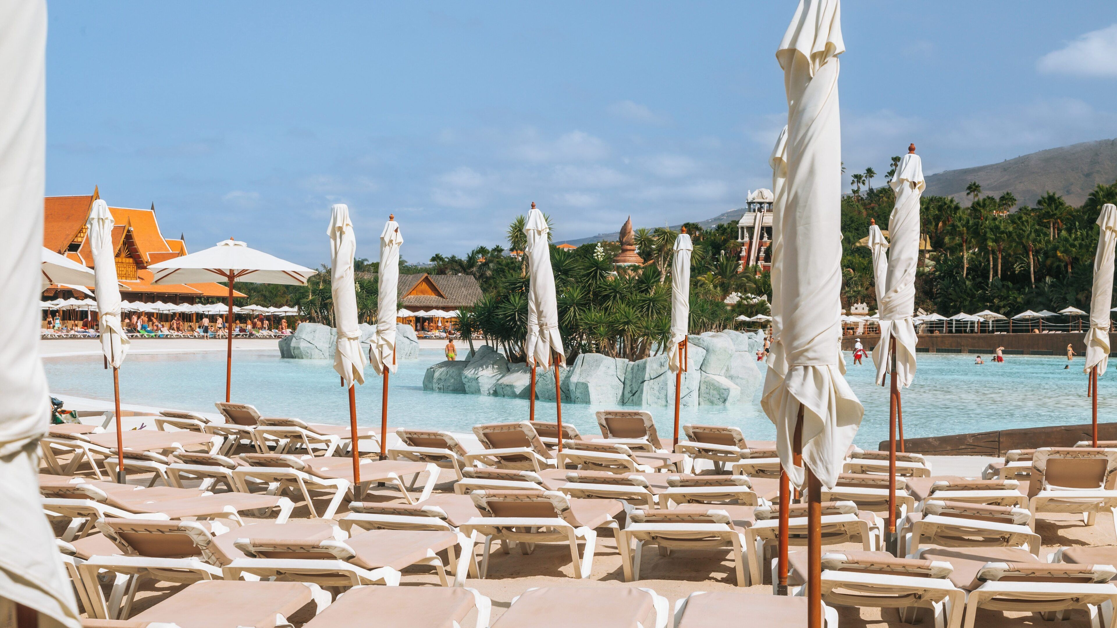 Relaxation area with sun loungers and umbrellas at Siam Park, a renowned water park in Costa Adeje, Canary Islands, Spain, perfect for family fun and leisure activities