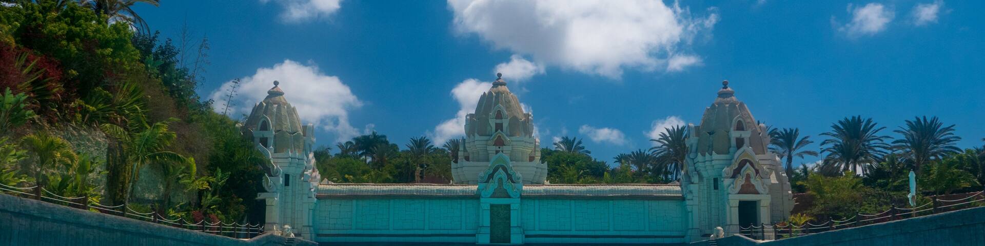 A clear blue pool with a temple-like structure in the background.