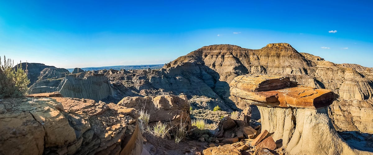 A rugged landscape with prominent rock formations and a clear blue sky.