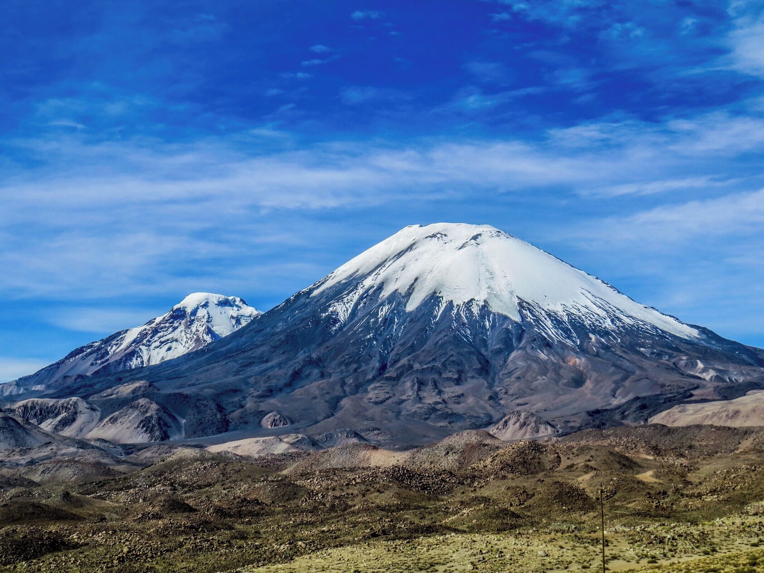 Parinacota and Pomerape volcanoes on the border of Chile and Bolivia. This photo was taken on the chilean side at Lauca National Park.