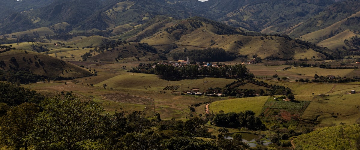 Rolling hills, a small town, and distant mountains.