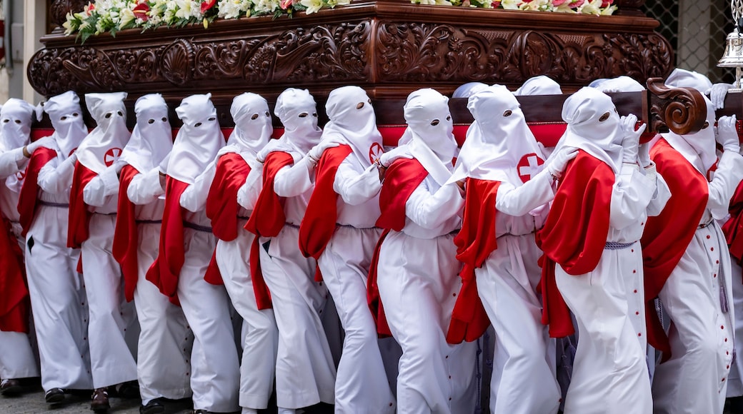 Penitents in White and Red March in Solemn Holy Week Observance