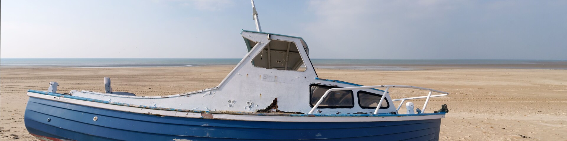Low tide and old abandoned boat in the Cotentin coast. The havre of Saint-Germain-sur-Ay