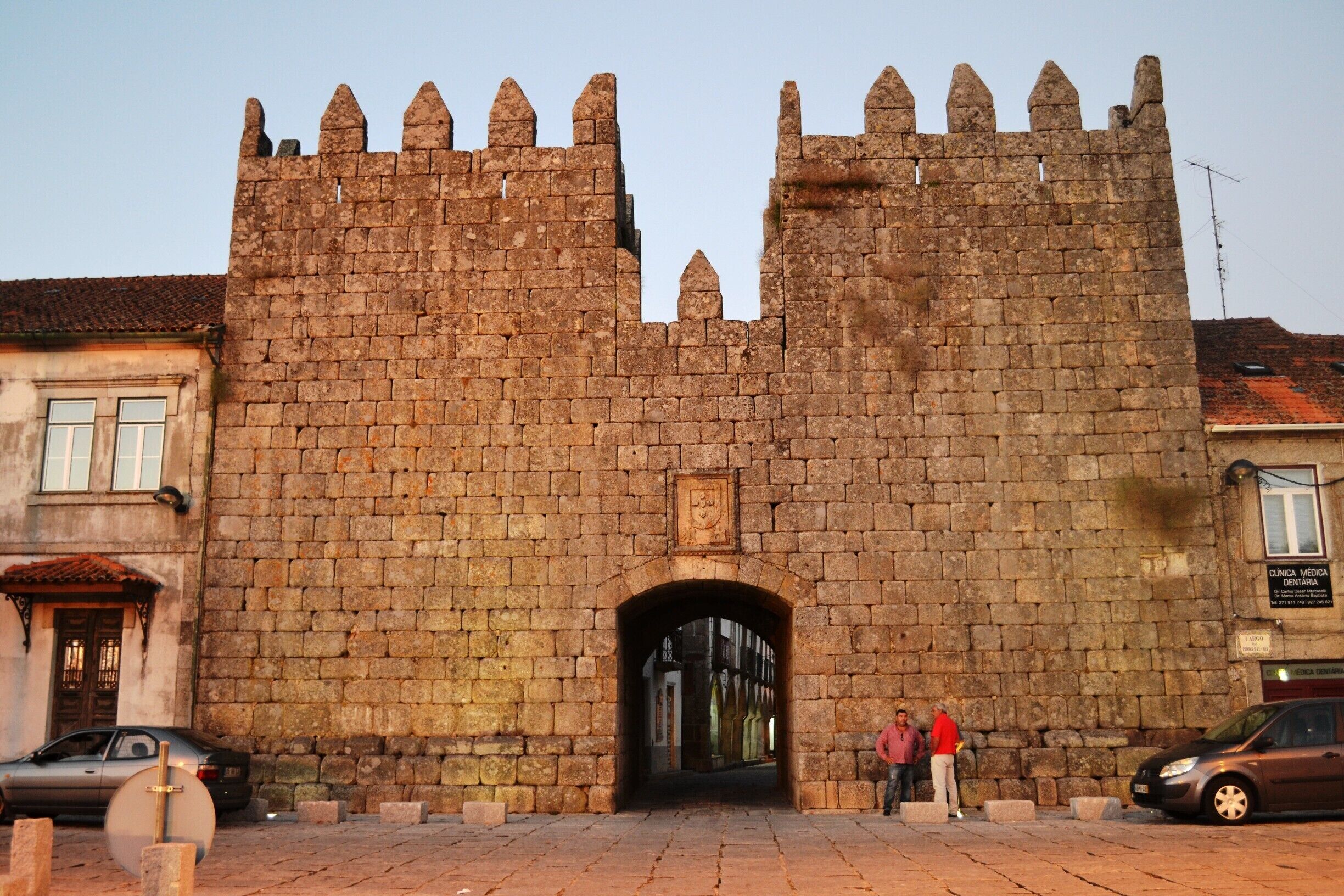 A historic stone castle entrance with two towers and a central archway.
