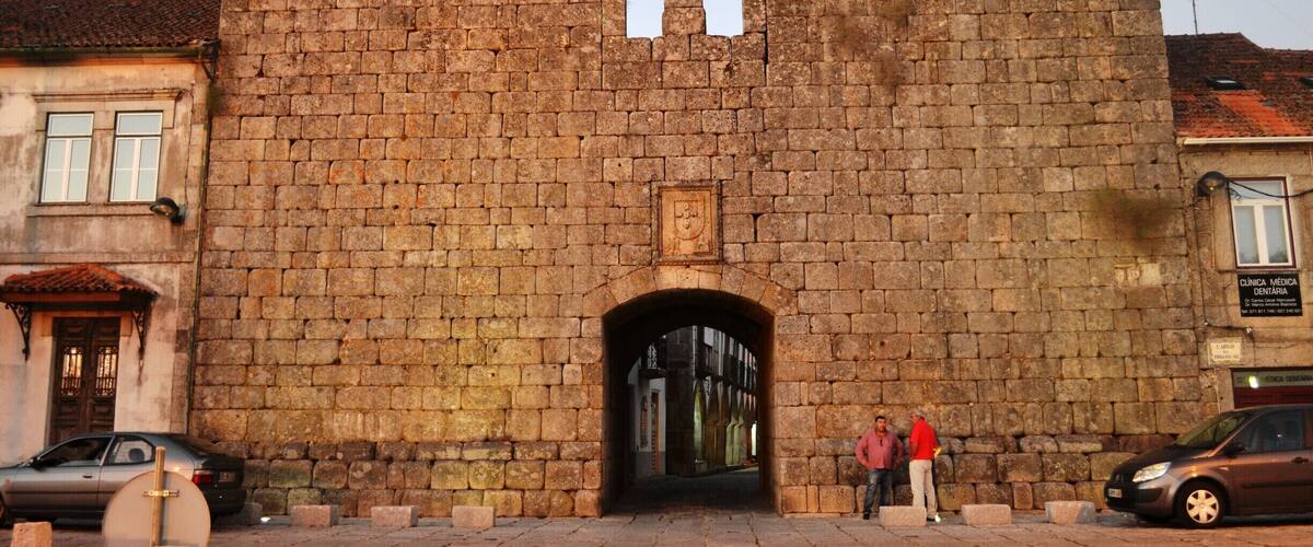 A historic stone castle entrance with two towers and a central archway.