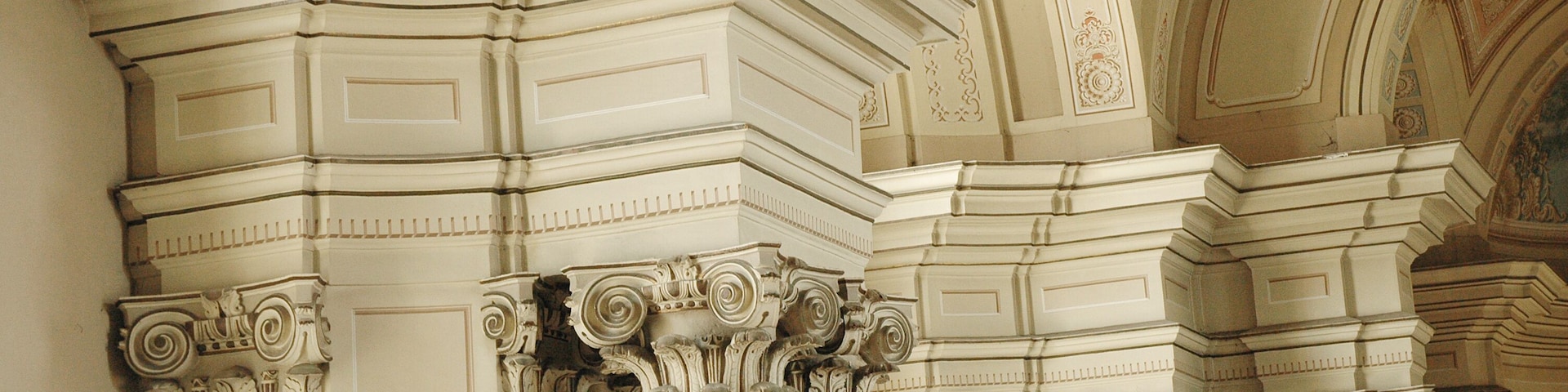 Columnas arquitectónicas ornamentadas con intrincados grabados y un techo con molduras elaboradas.