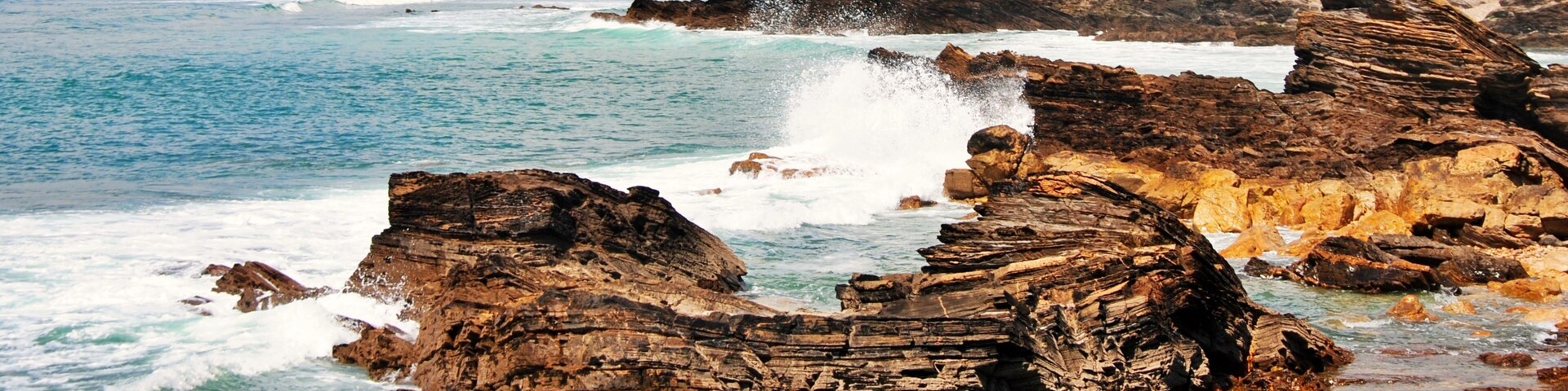 A rocky coastline with waves crashing against the rocks.