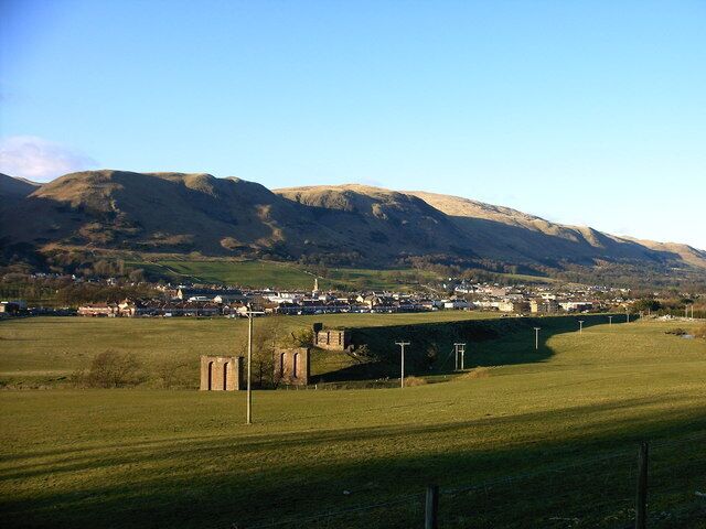 A rural landscape with a bridge, fields, and a town in the valley.
