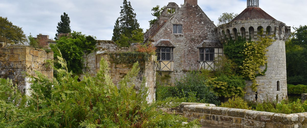 A historic stone building with ivy-covered walls and a turret.