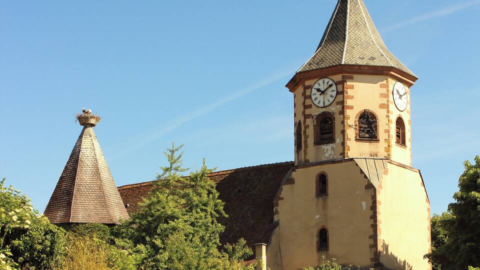 A church with a clock tower and a conical roof.