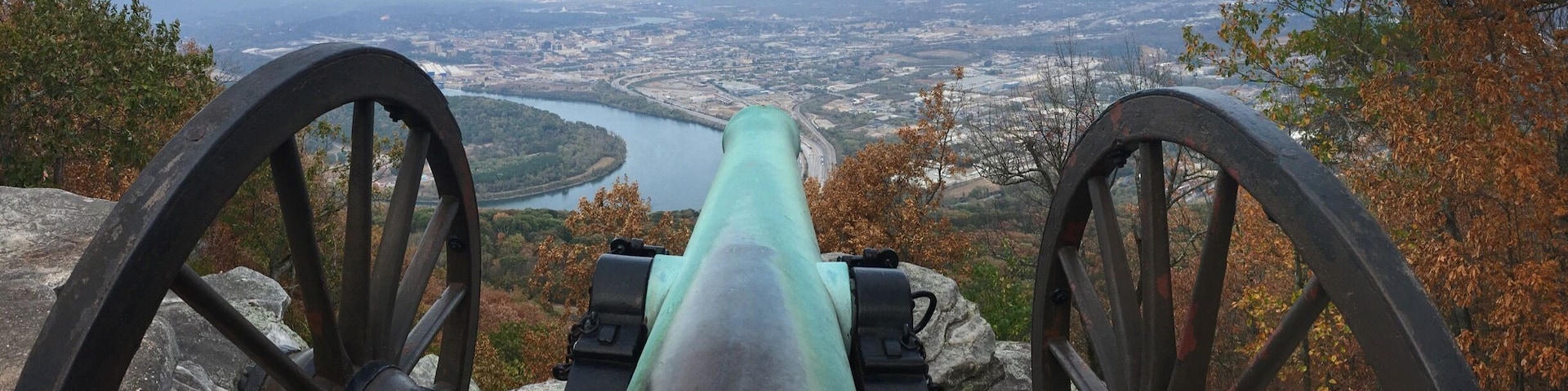 Eine Kanone mit Blick auf eine Stadtlandschaft und einen Fluss.