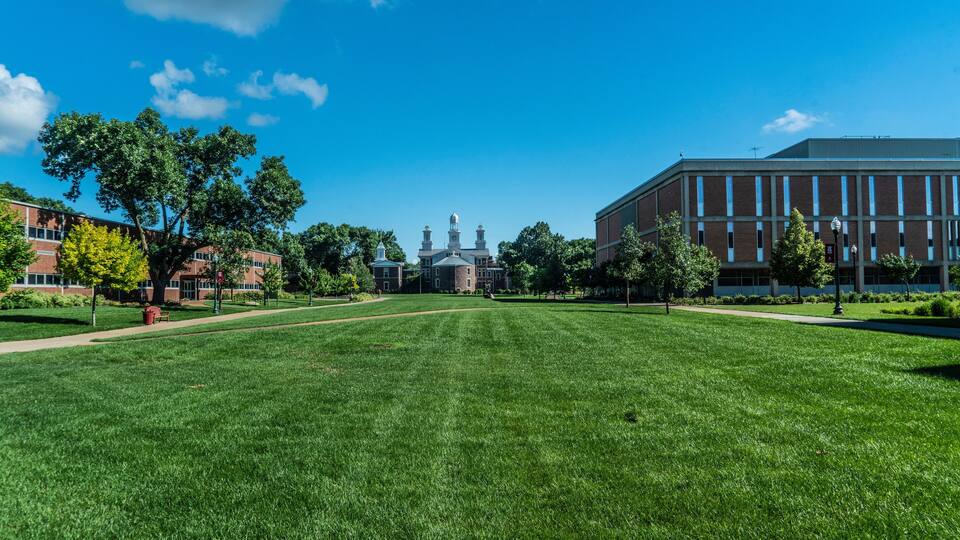 A grassy field with a building in the background.