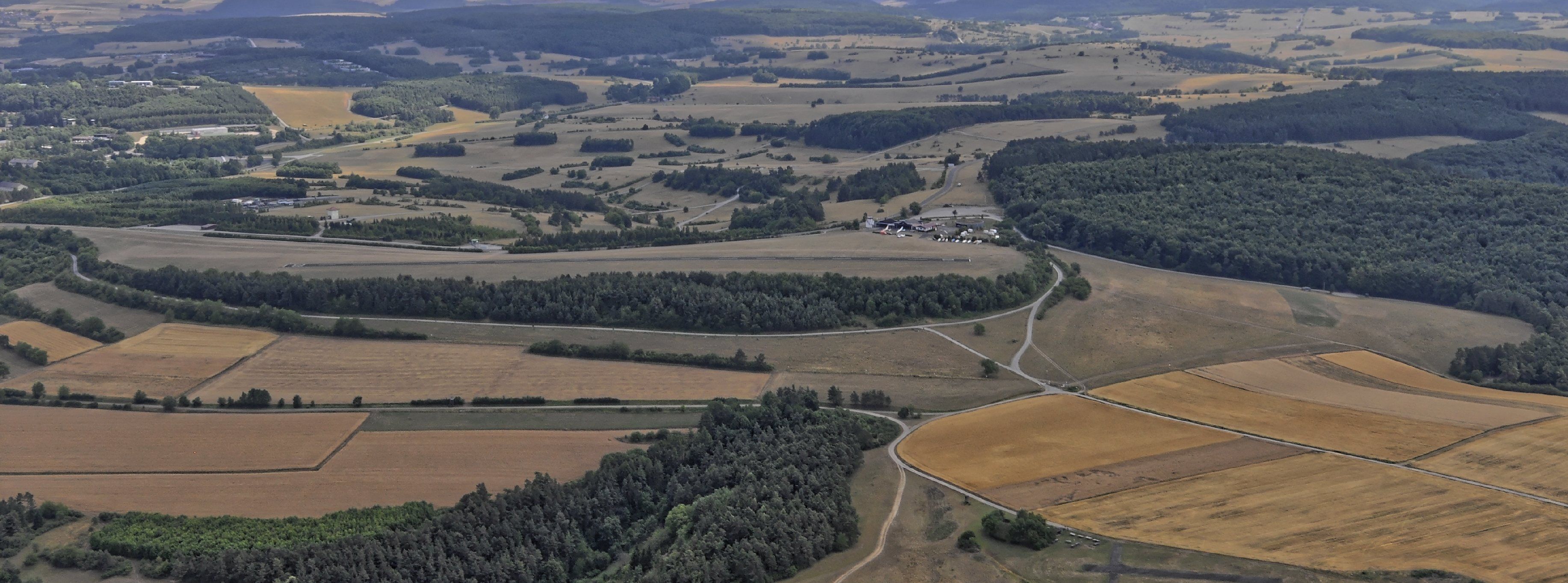 Bilder vom Flug Nordholz-Hammelburg 2015: Blick von Norden auf den Flugplatz Lager Hammelburg; die Start- und Landebahn verläuft in der Bildmitte von links nach rechts.