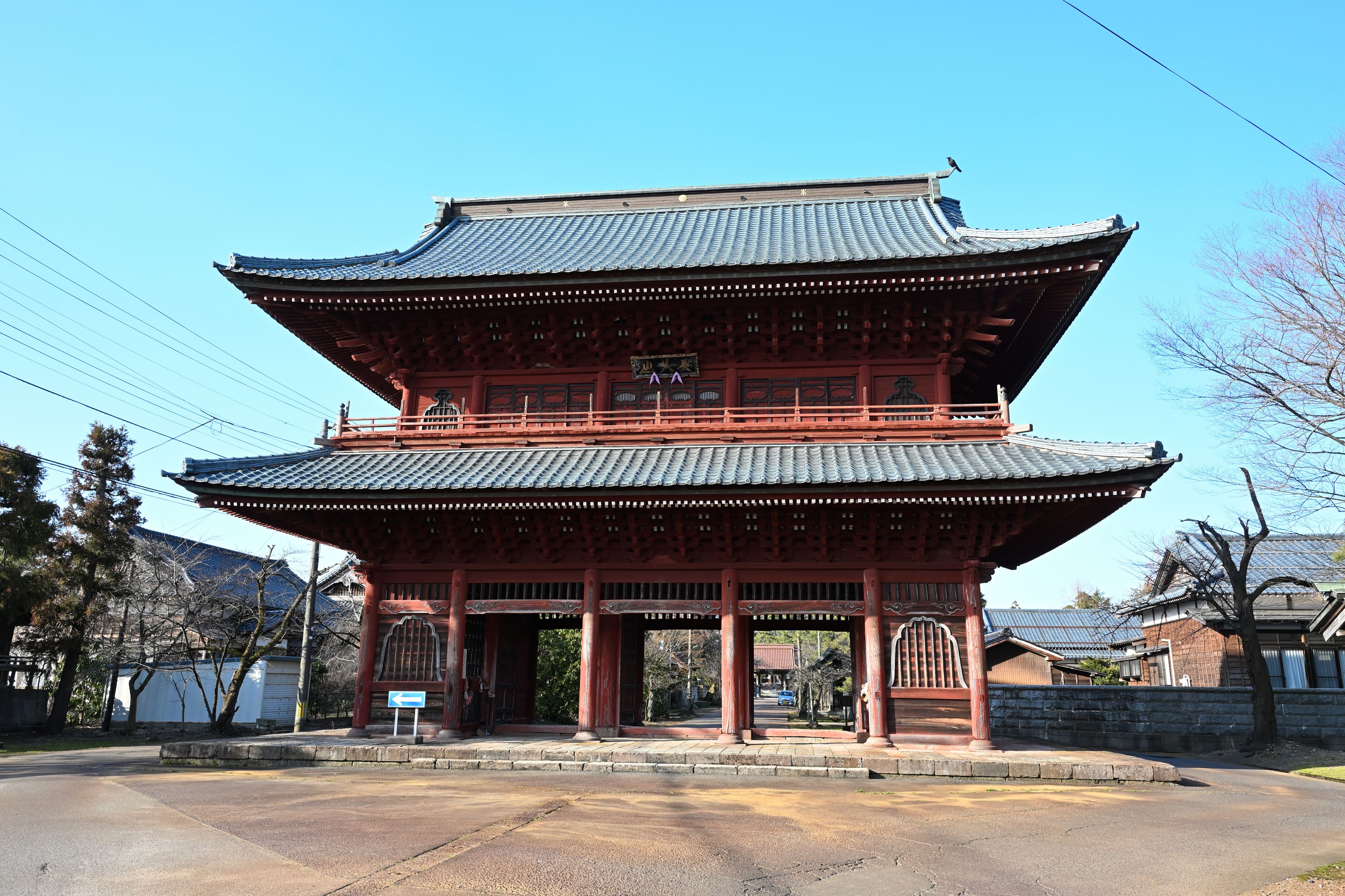 A traditional Korean gate with a curved roof and red pillars.