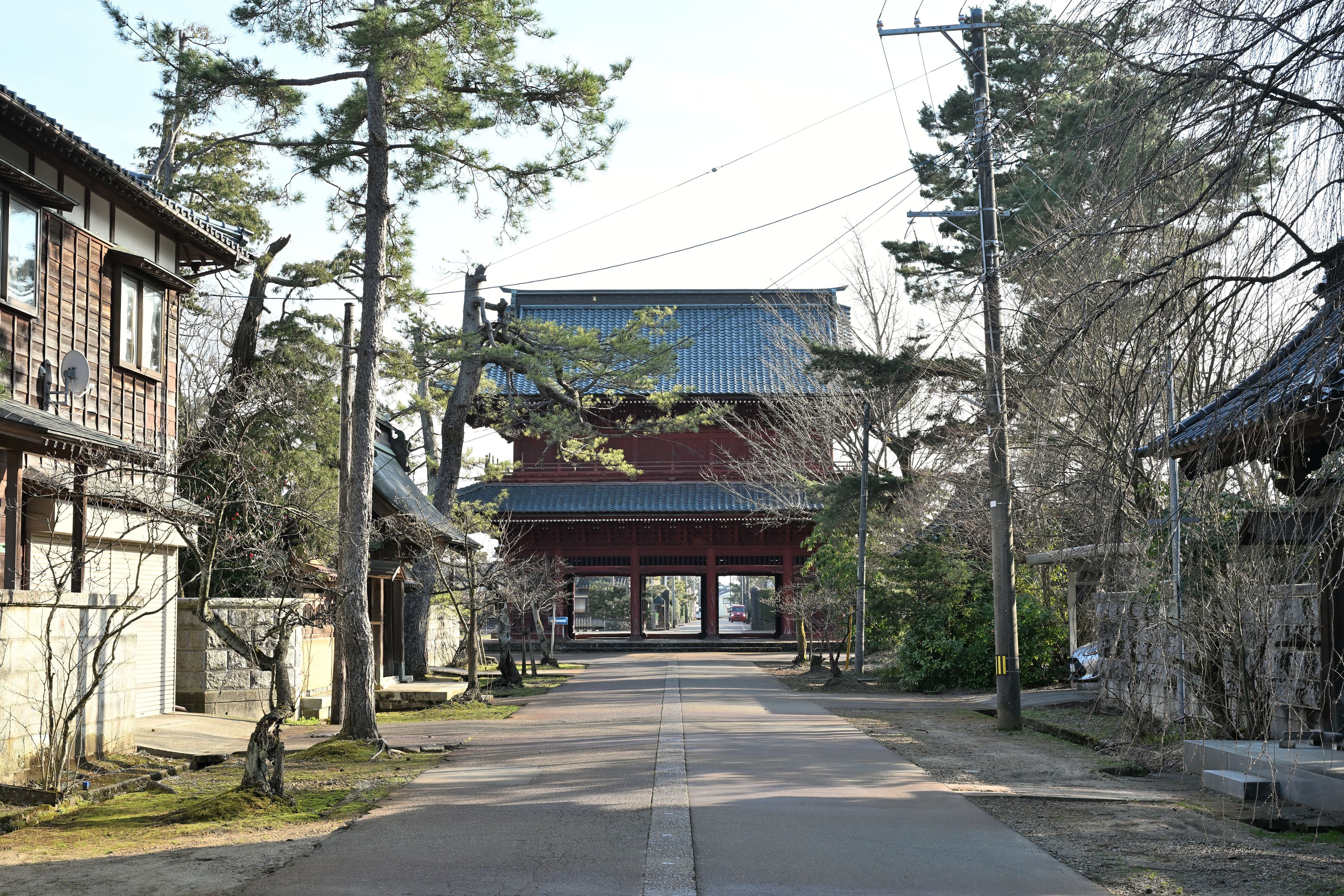 A traditional Japanese building with a tiled roof and a wooden structure on the left.