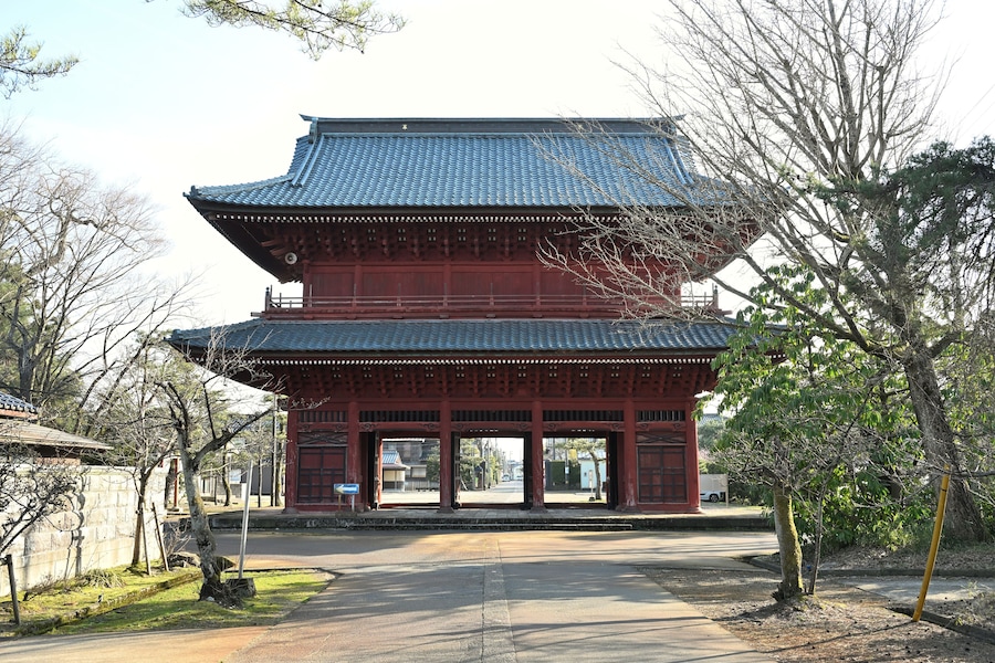 Un edificio japonés tradicional con techo de tejas y paredes rojas.