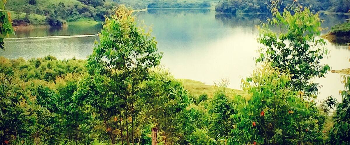 A lake surrounded by lush green hills and trees.