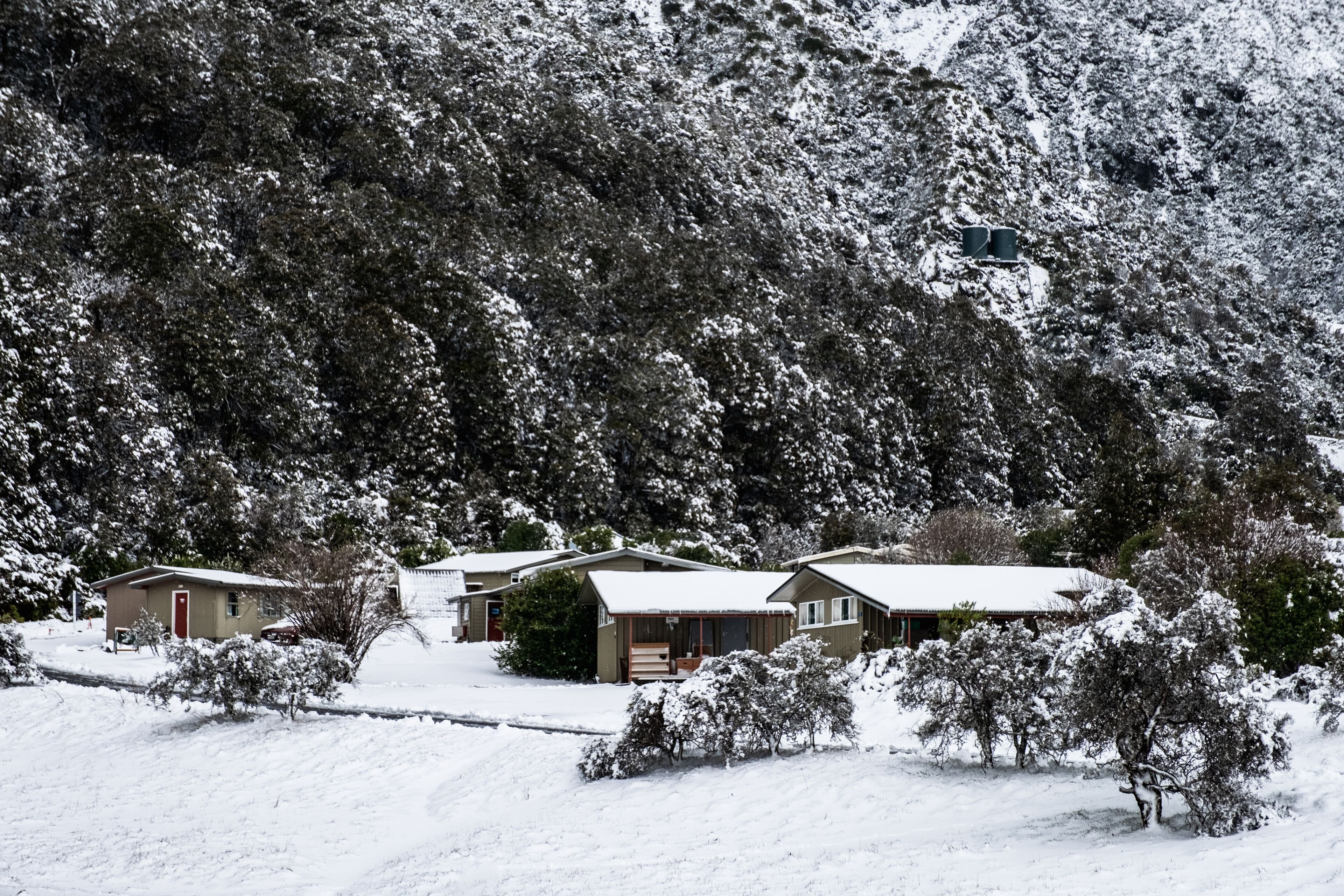 View of the houses in Mount Cook Village covered with white fresh snow in a snowy day.